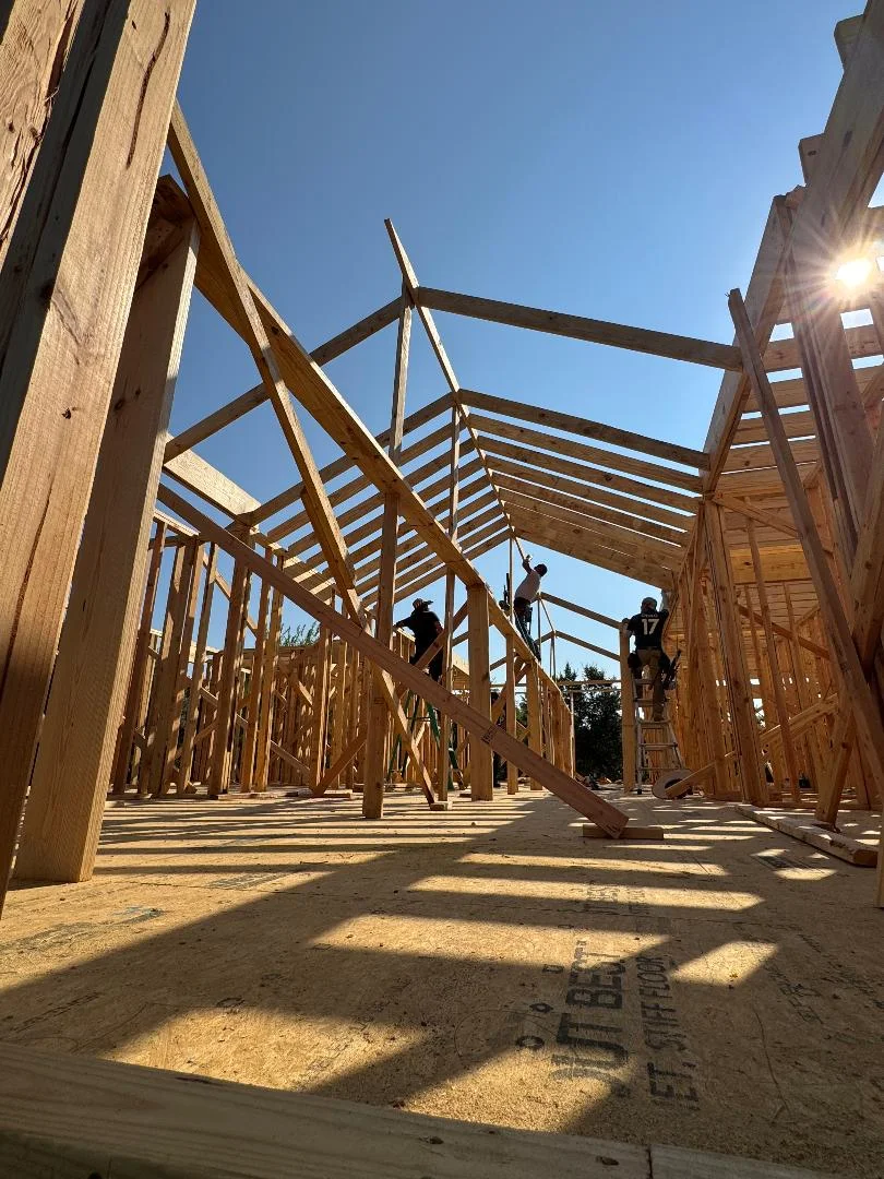 Residential wood framing with engineered beams, rafters, and wall studs during active construction
