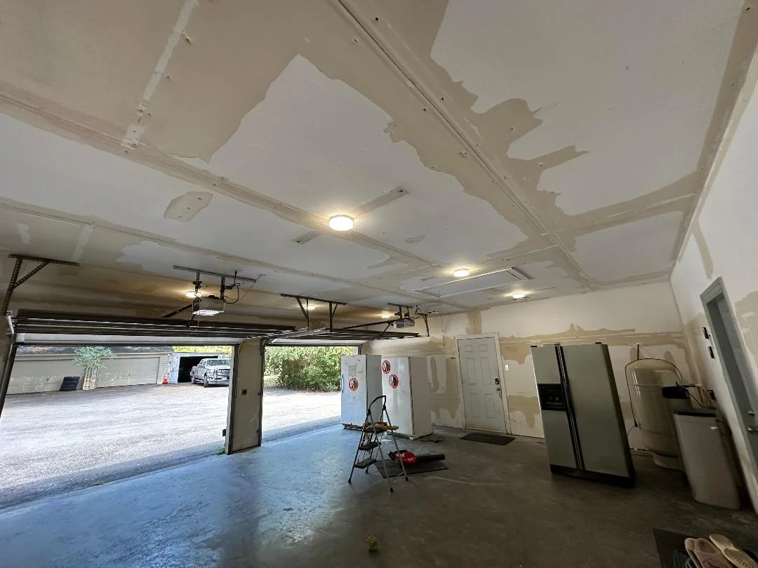 Garage interior with new drywall ceiling, recessed lighting, and finished wall installation